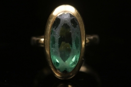 Golden ring with green glass stone